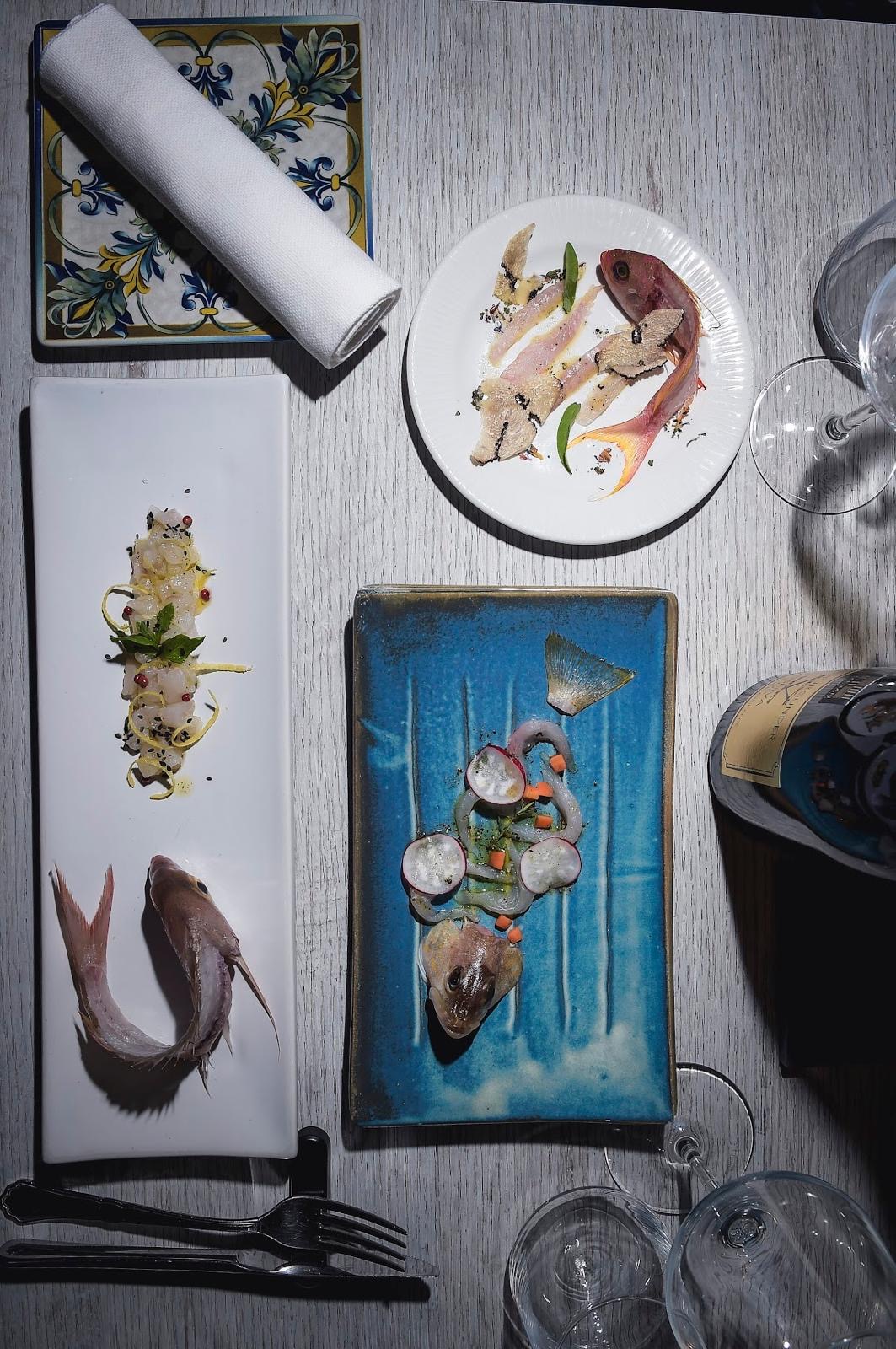 Tavolo apparecchiato con crudi di pesce